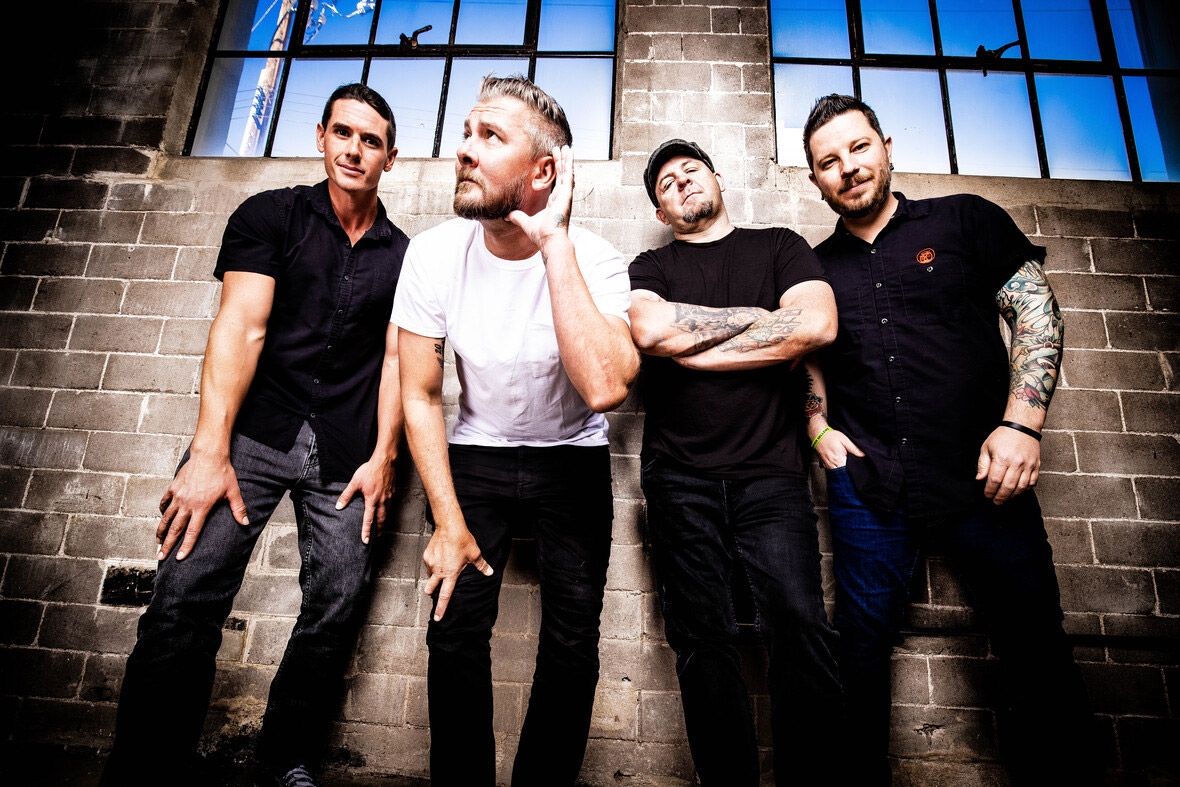 Promotional photo of Authority Zero standing in front of a brick wall